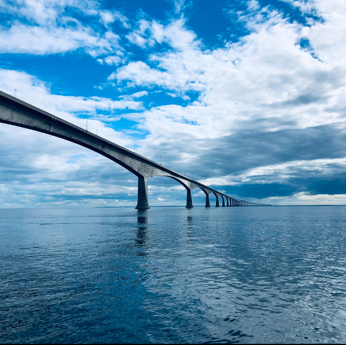 Confederation Bridge spanning the calm blue waters around Prince Edward Island - showcasing the beautiful maritime setting perfect for paddle boarding adventures